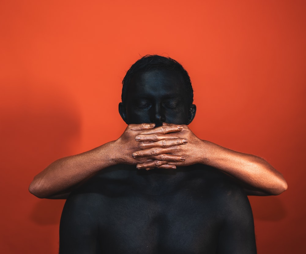 a man covered in black paint covering his face