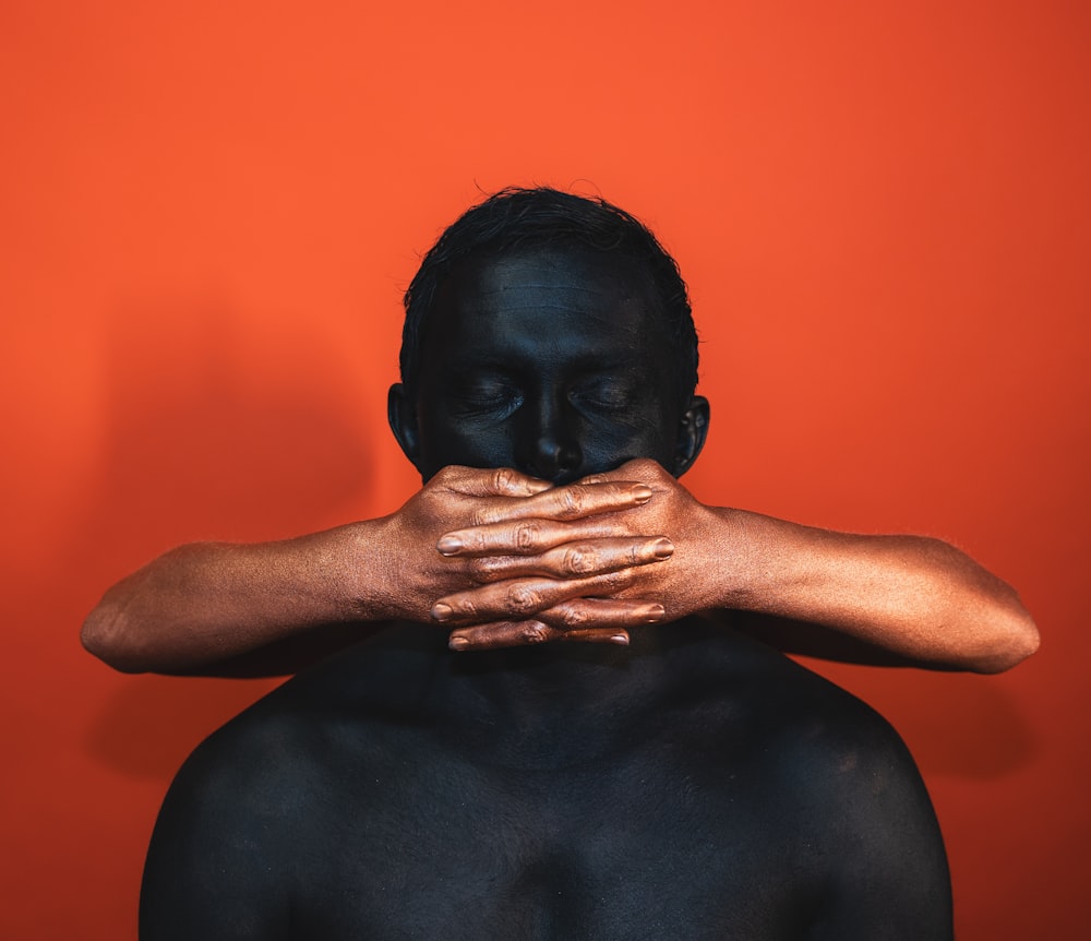 a man covering his face with his hands