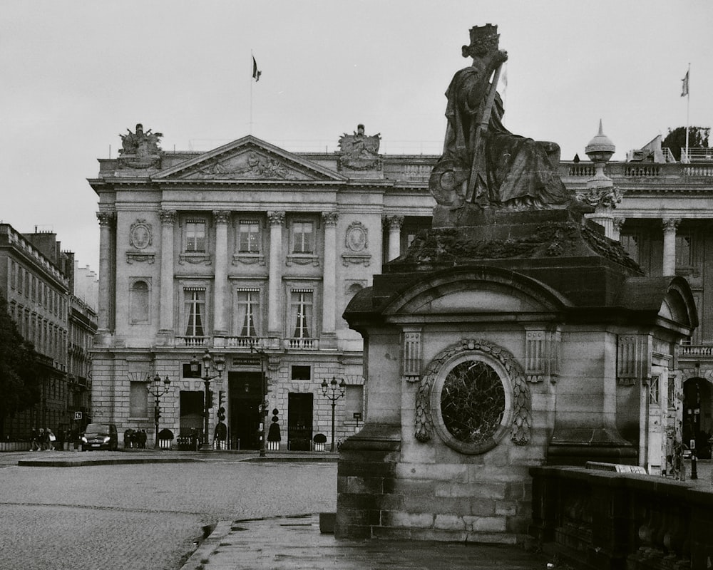 uma foto em preto e branco de uma estátua em frente a um edifício