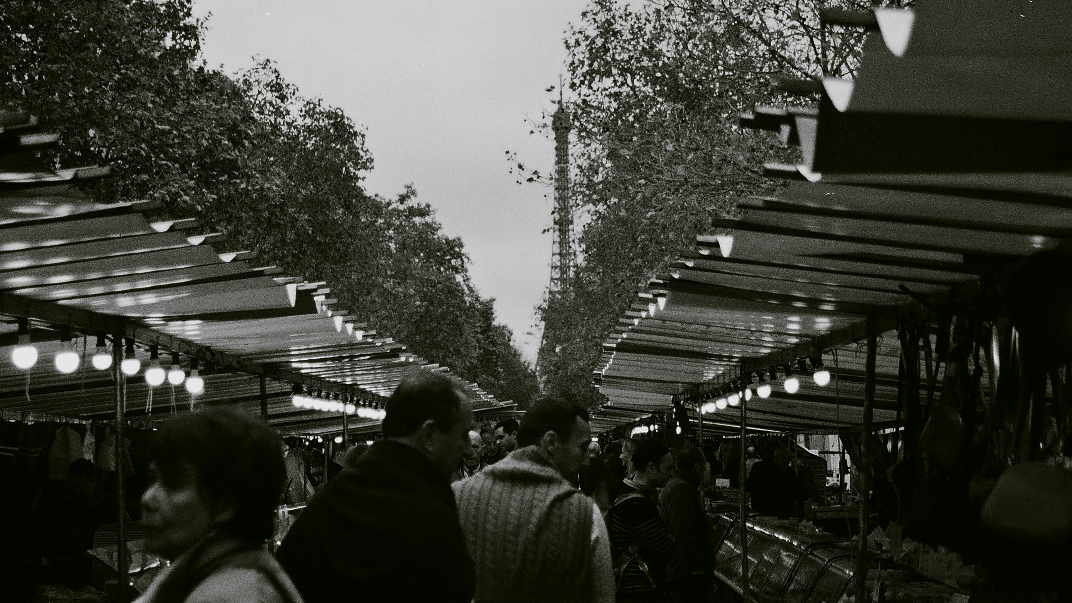a black and white photo of people walking down a street