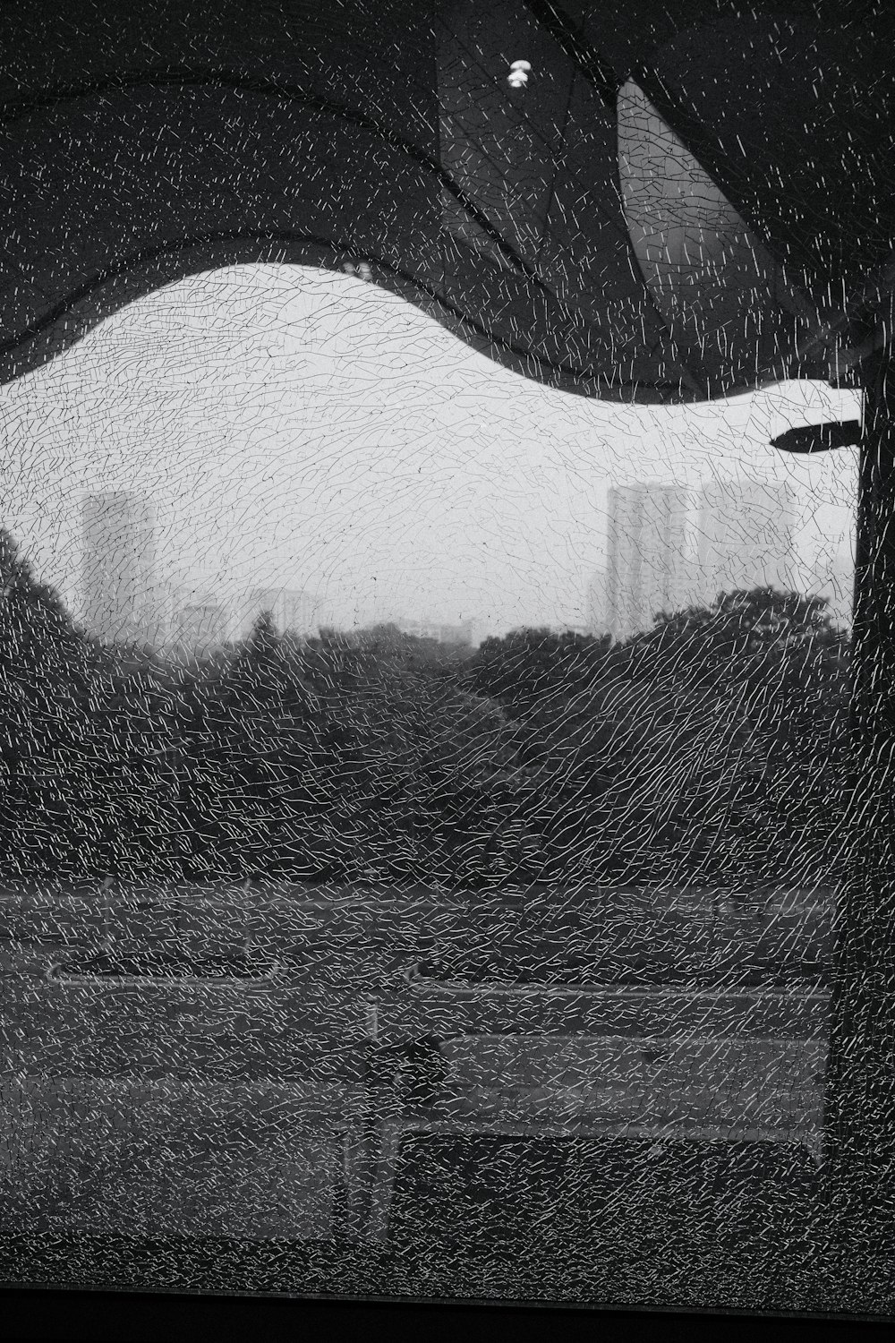 a black and white photo of a window with a view of a city