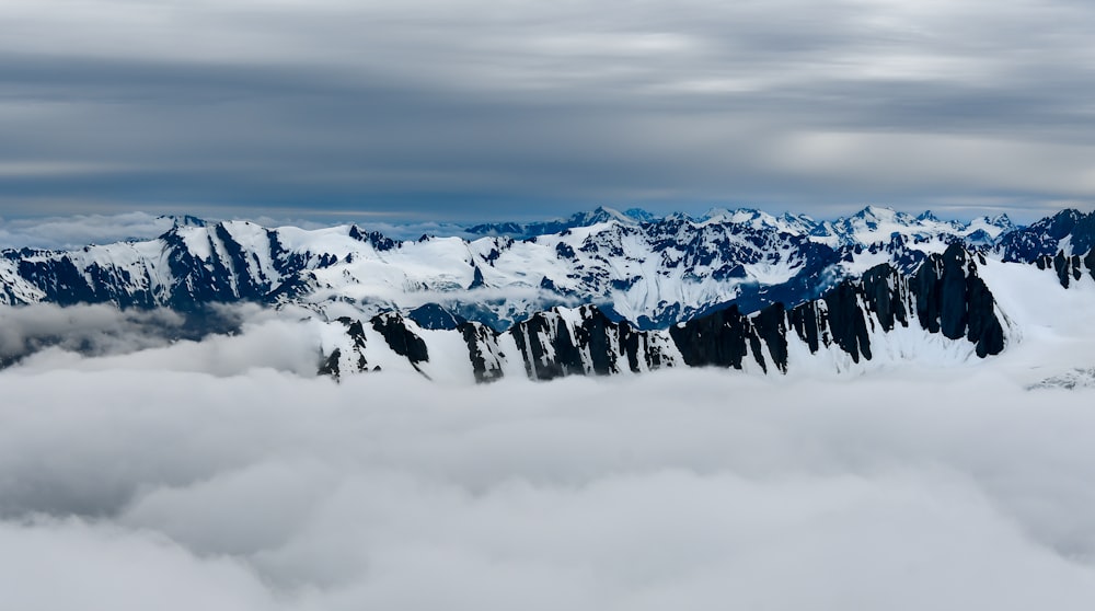 a mountain range covered in snow and clouds