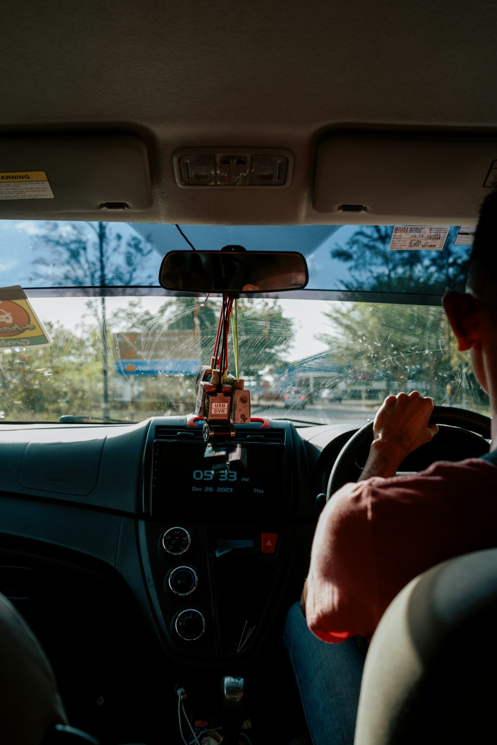 a man driving a car with a steering wheel