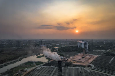 Industrial pyrolysis unit operating amidst agricultural fields in Pakistan during golden hour.