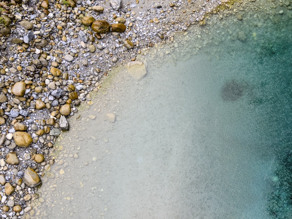 a body of water surrounded by rocks and gravel