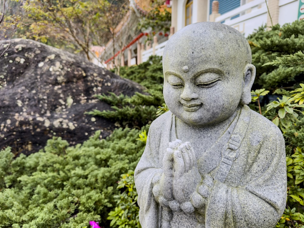 une statue d’un bouddha dans un jardin
