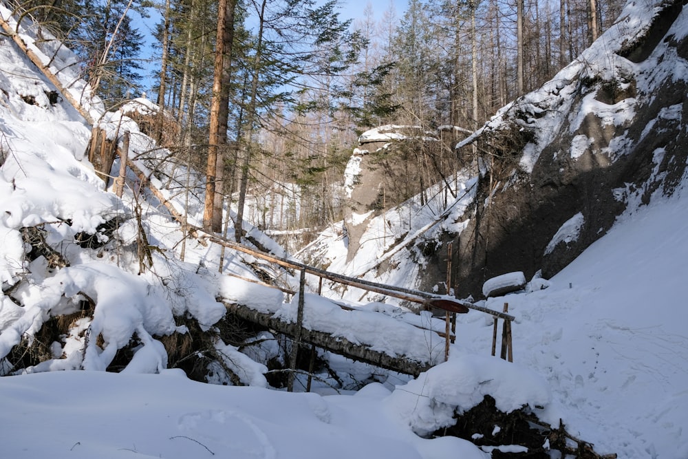 a snow covered mountain with a wooden bridge