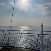 A peaceful ocean view from the deck of a cruise ship at sunrise.