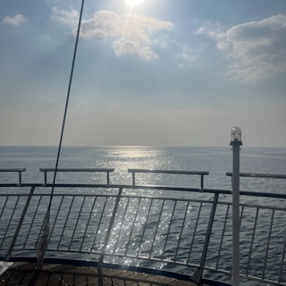 A peaceful ocean view from the deck of a cruise ship at sunrise.