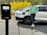 A happy customer standing next to their repaired electric car.