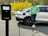 A happy customer standing next to their repaired electric car.