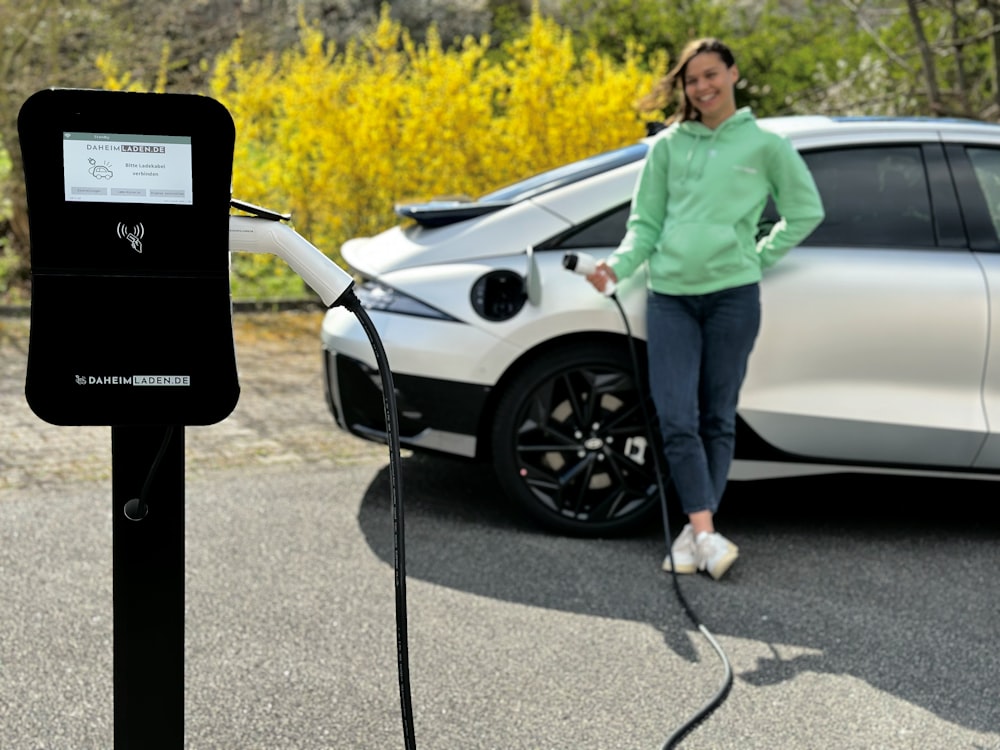 a woman is charging a car in a parking lot