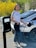 a woman standing next to a car with an electric charger