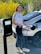 a woman standing next to a car with an electric charger