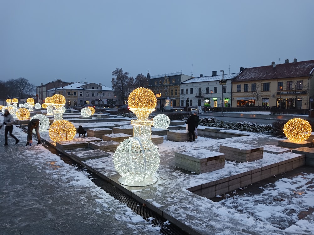 a group of people walking through a snow covered park