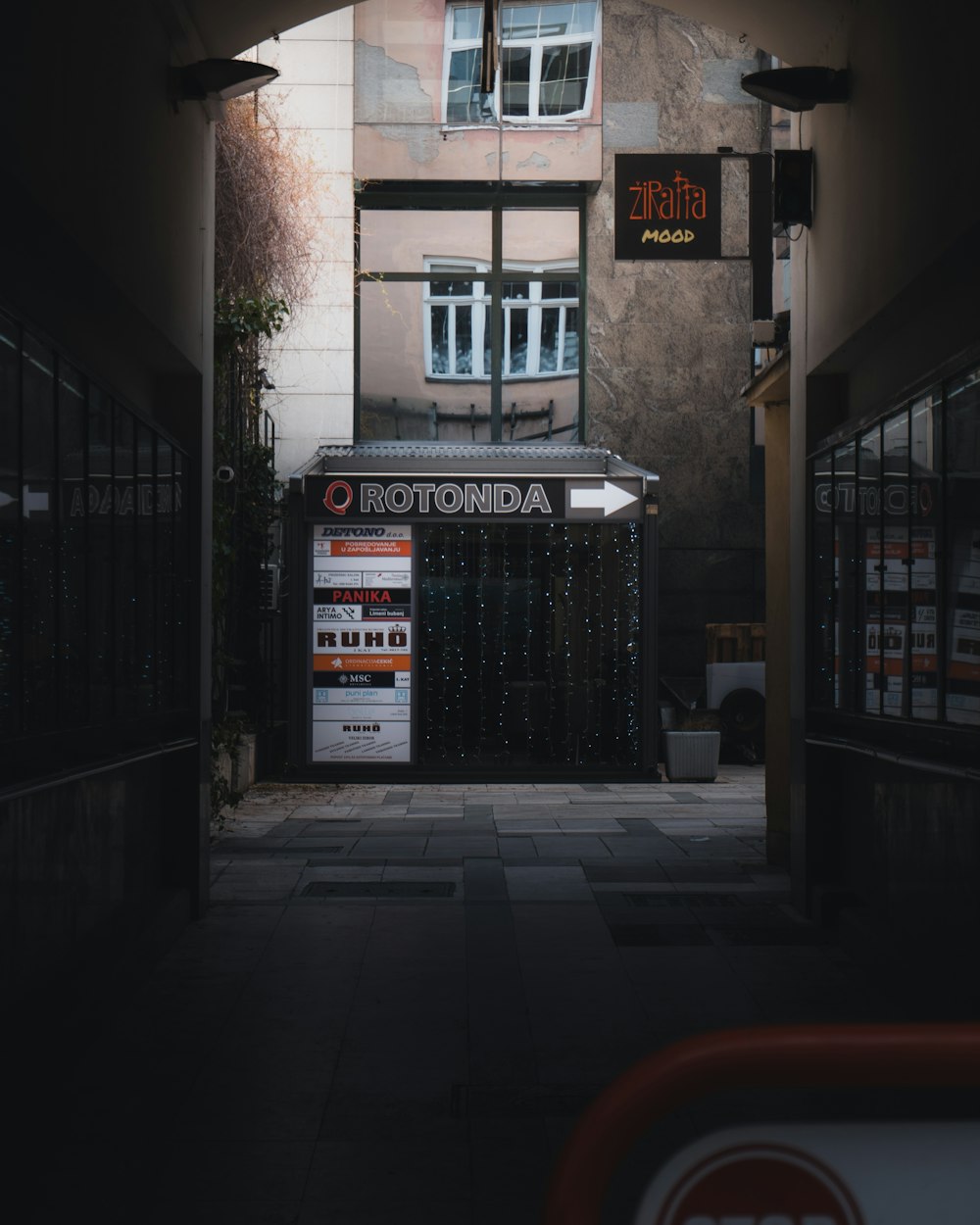 an alley way with a store sign and a building in the background