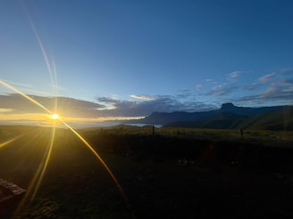 A scenic view of a sunrise over rolling hills and farmland.