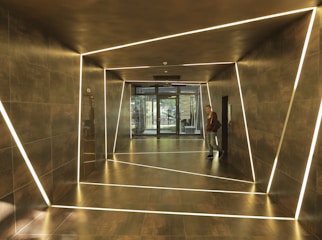 Electrician installing modern lighting fixtures in a residential hallway