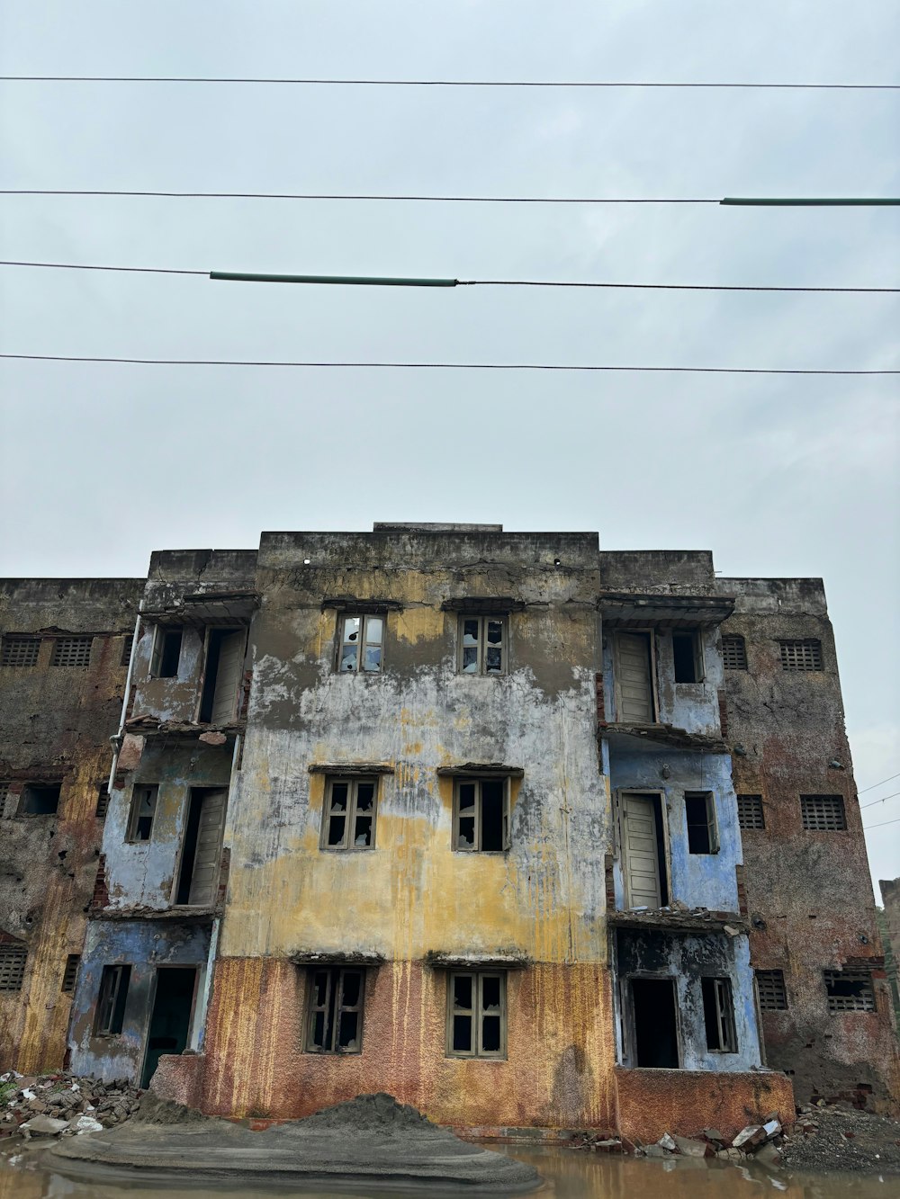 an old building with broken windows on a cloudy day