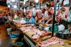 Fresh minced meat and sausages neatly packaged on a market counter.