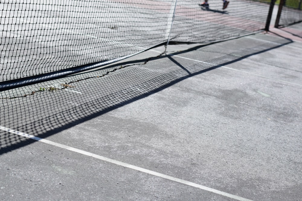 a tennis court with a net and two people playing tennis