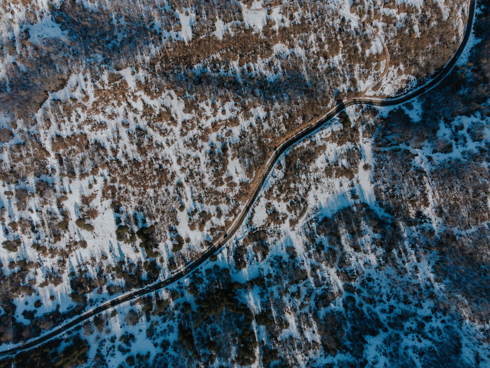 an aerial view of a winding road in the snow