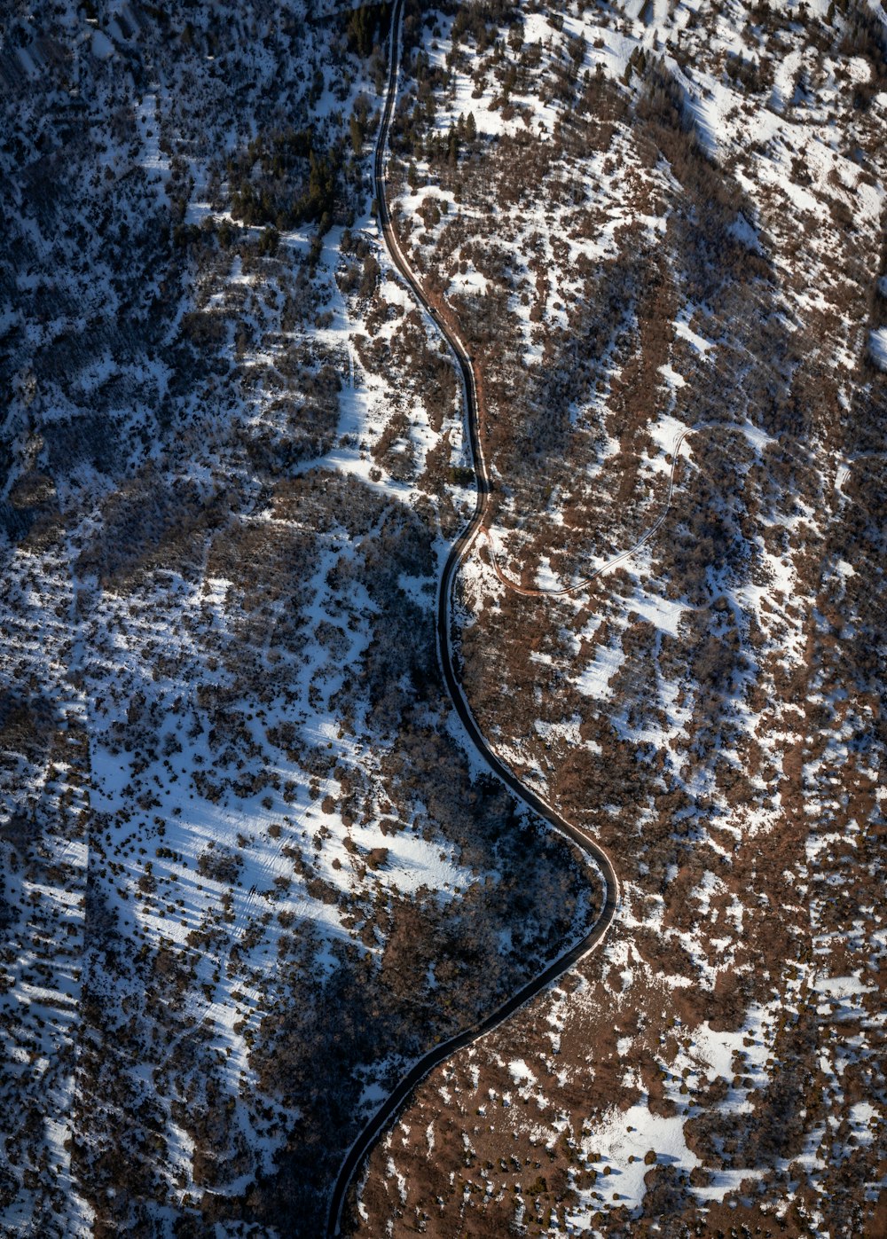 an aerial view of a winding road in the mountains