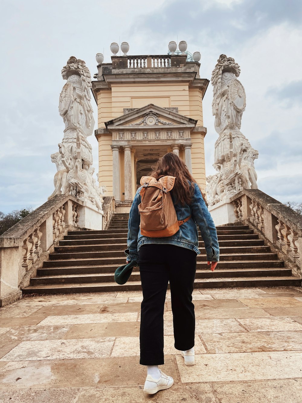 a woman with a backpack walking towards a building