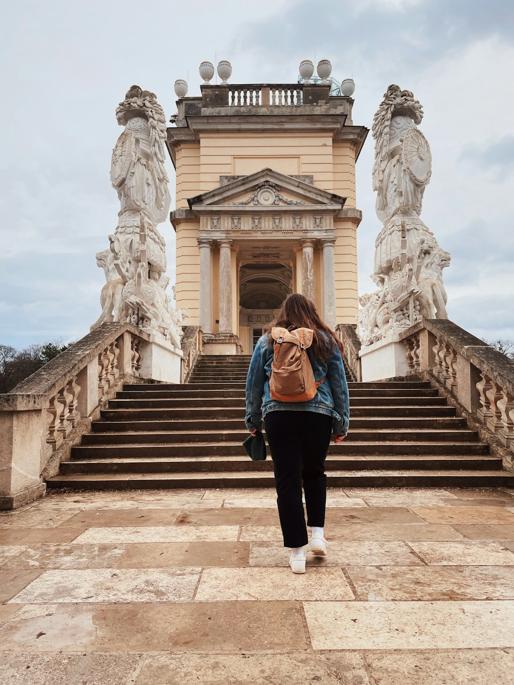 a woman with a backpack walking up a set of stairs