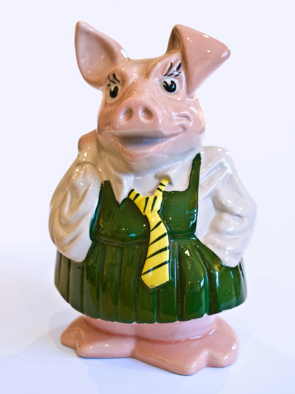 a ceramic pig wearing a green dress and a yellow tie