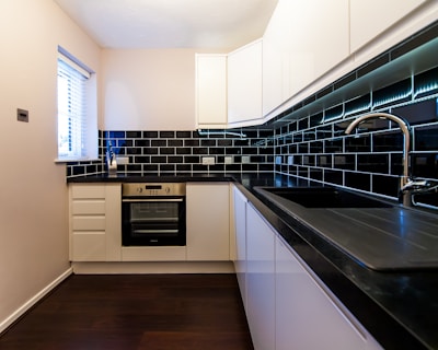 a kitchen with a black counter top and white cabinets