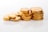 Piles of shiny gold coins are arranged on a smooth, reflective surface. The coins are stacked in various heights and the lighting highlights their metallic sheen.