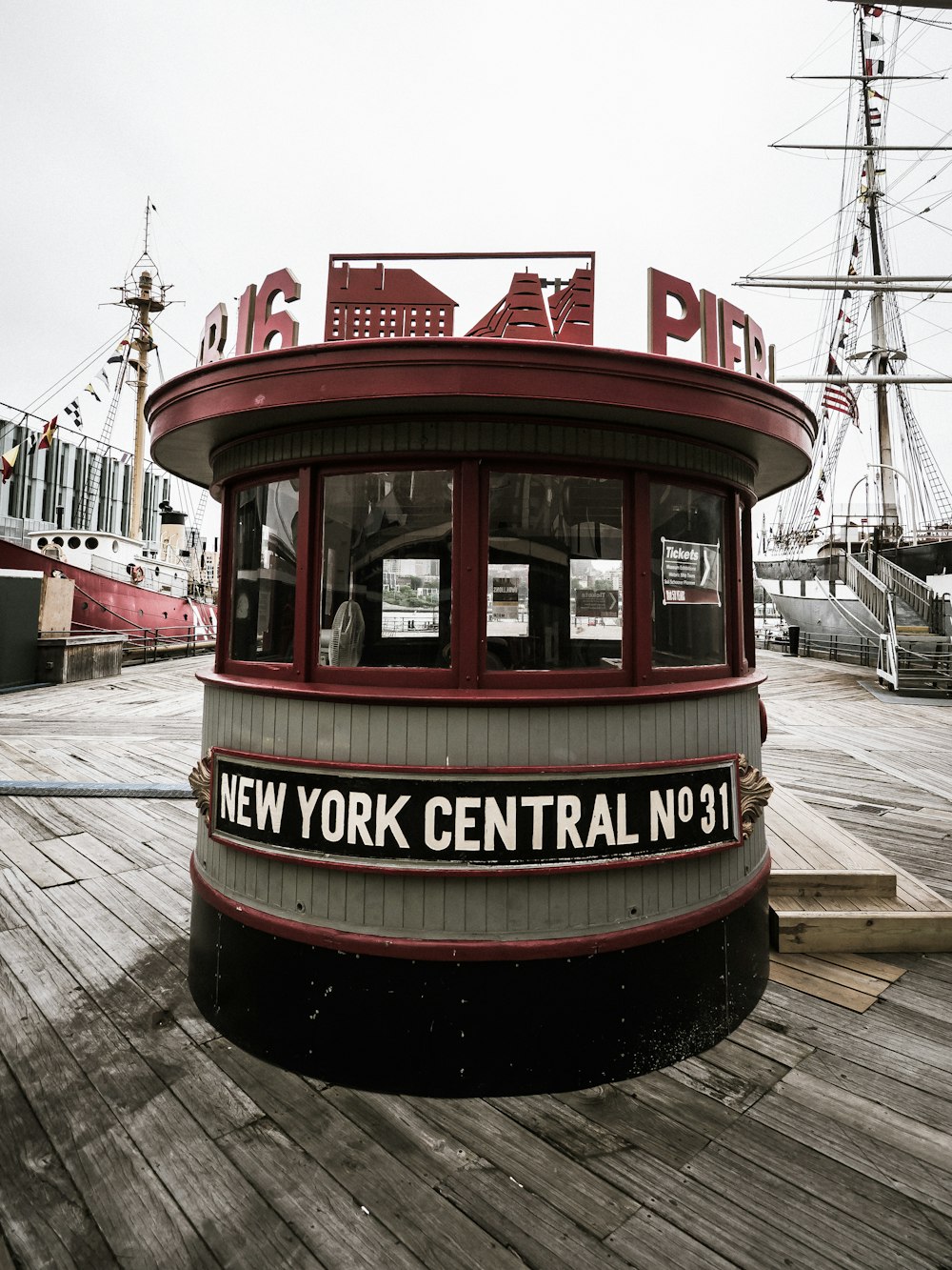 a red and white boat sitting on top of a wooden dock