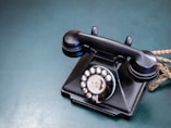 an old - fashioned rotary telephone sits on a table