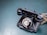 A vintage black rotary telephone with a coiled cord is placed on a flat, textured blue-green surface. The rotary dial is prominently featured, displaying numbers and letters.