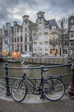 A bicycle parked outside a charming Amsterdam canal house where massage is offered.