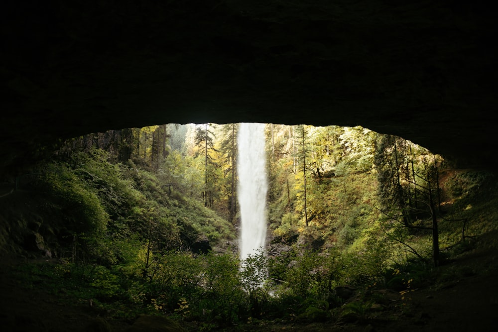 a view of a waterfall from inside a cave