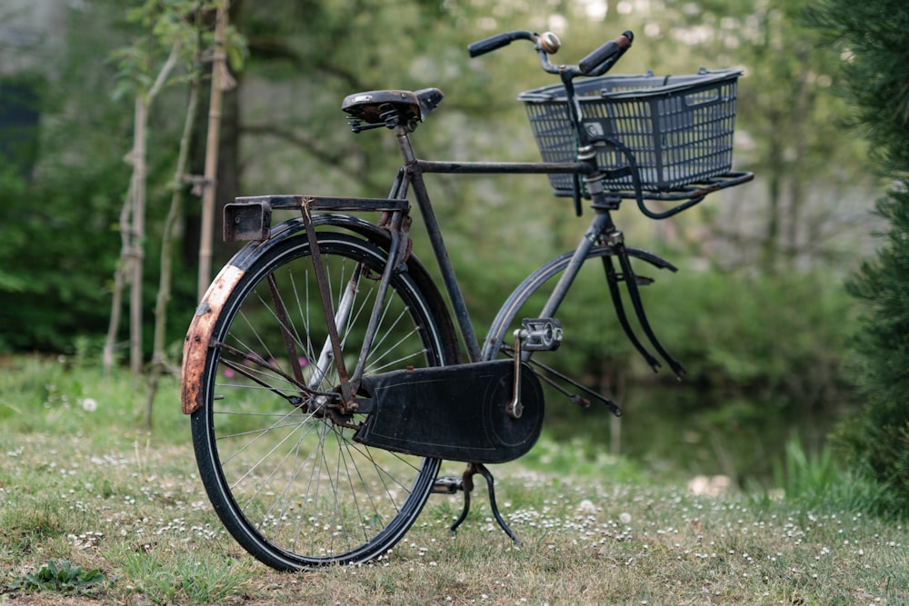 an old bicycle with a basket is parked in the grass