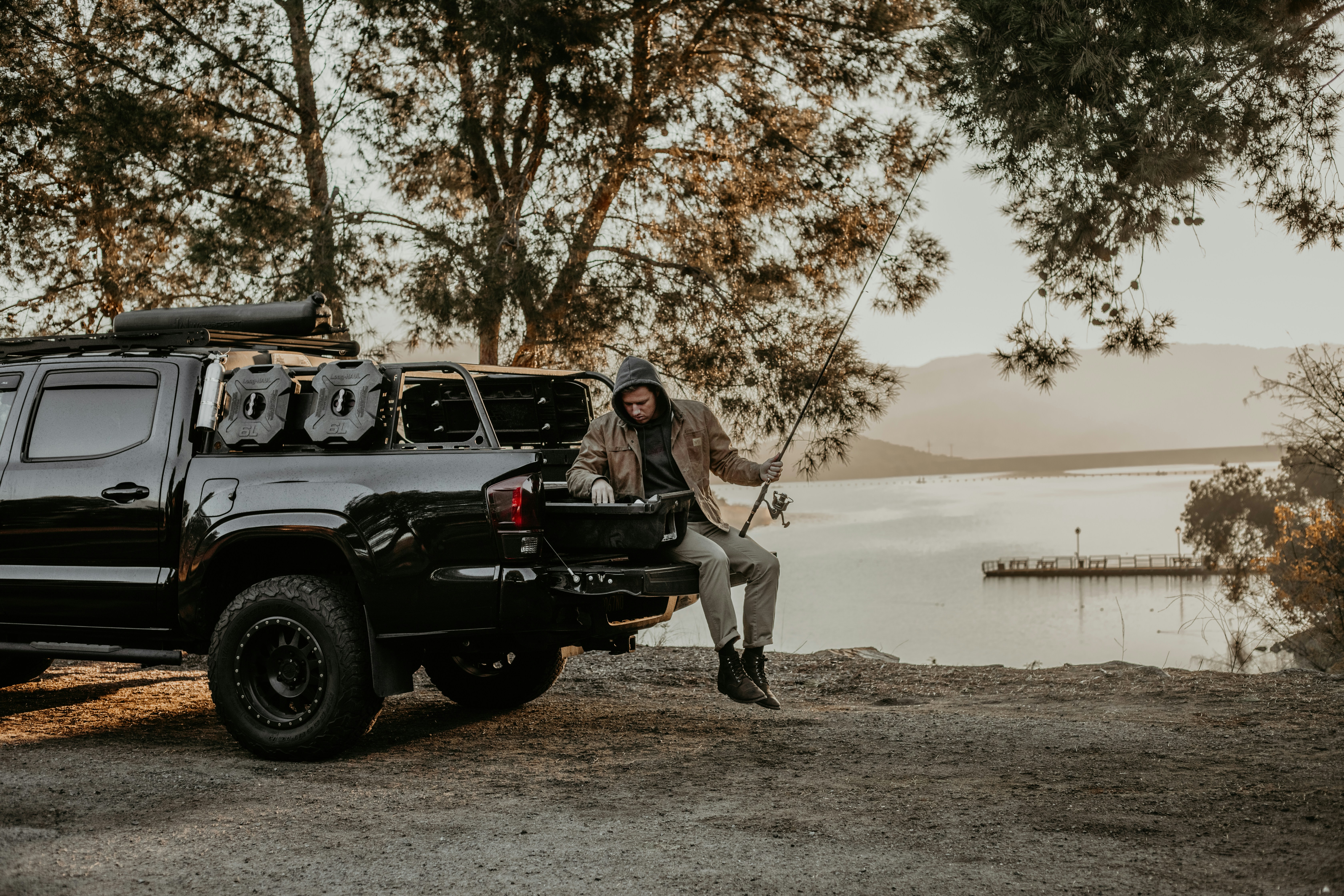 a man sitting on the back of a black truck