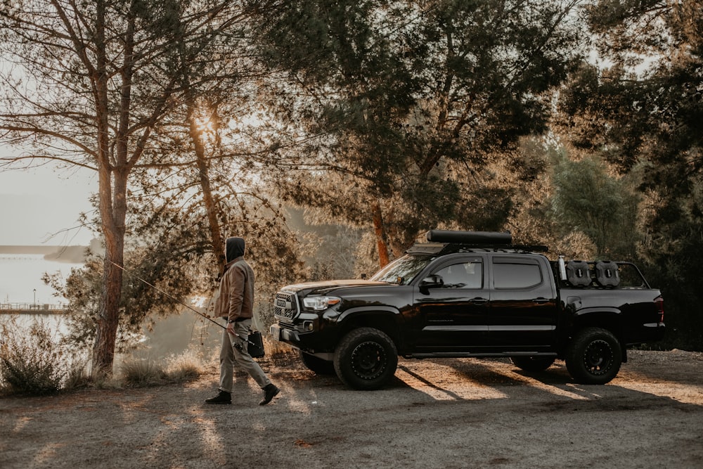 a man walking next to a black truck