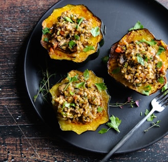 a black plate topped with three stuffed acorns