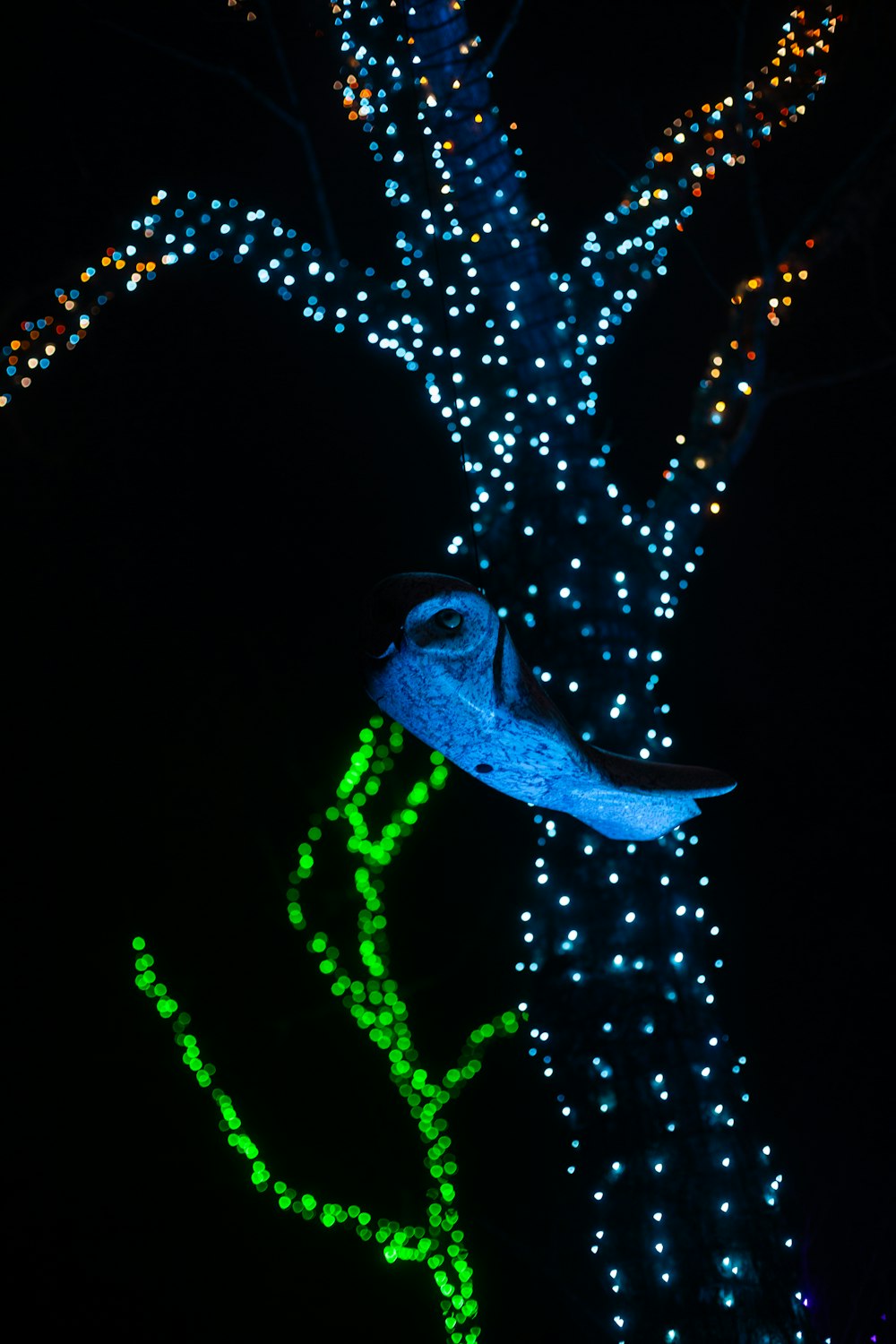 a tree decorated with lights in the dark