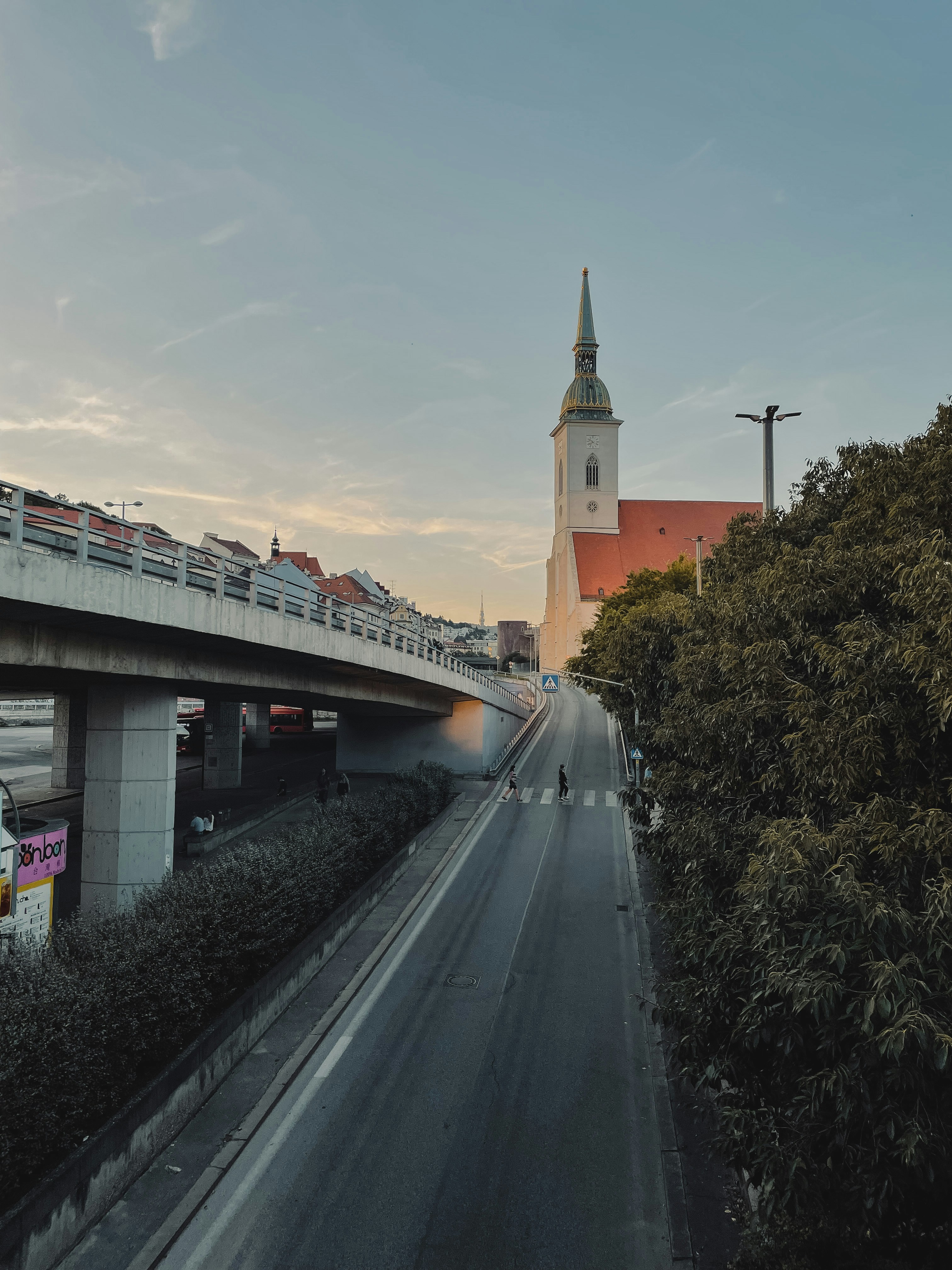 a view of a street with a bridge and a clock tower in the background