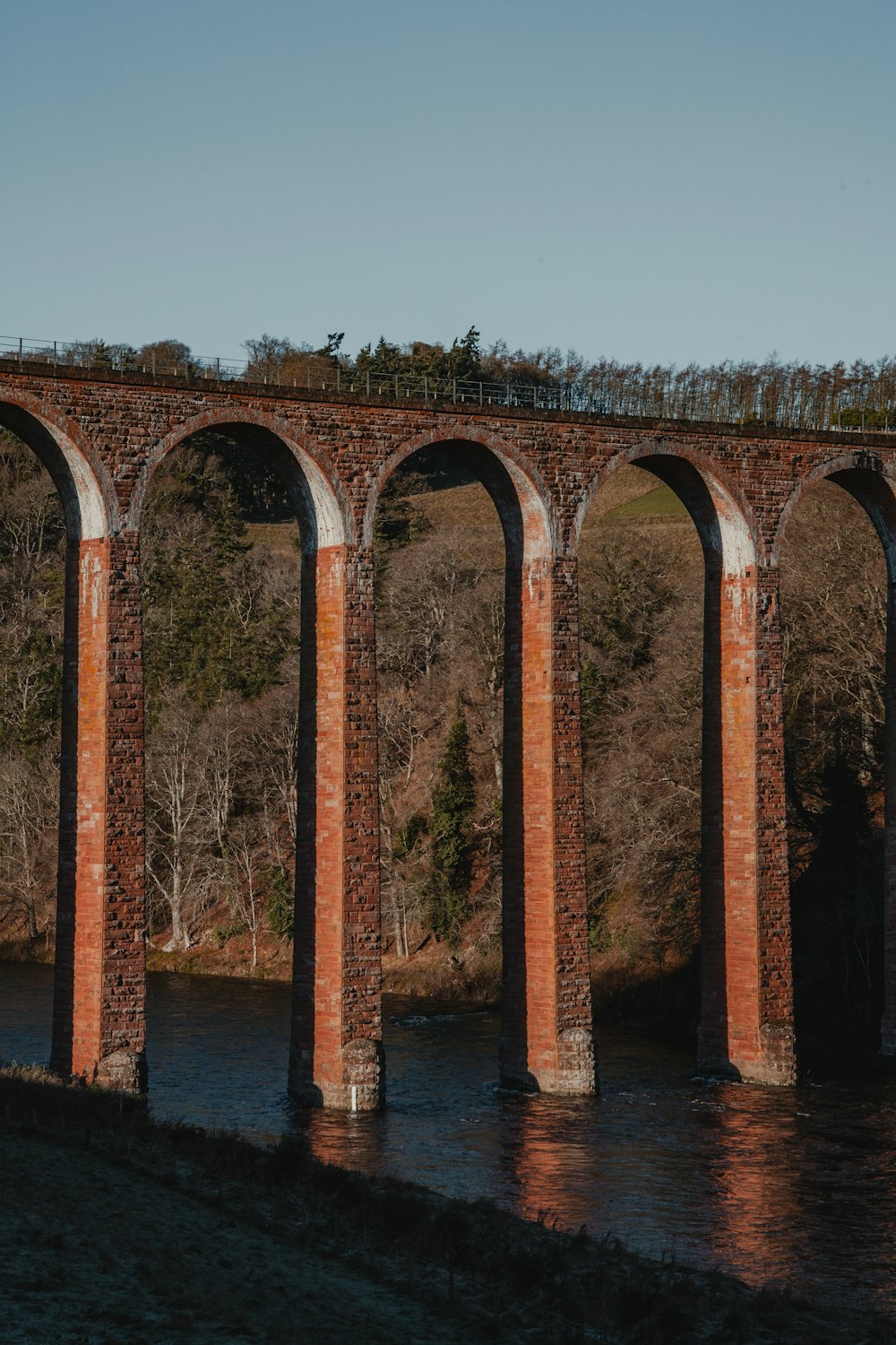 Un viejo puente ferroviario de ladrillo sobre un río