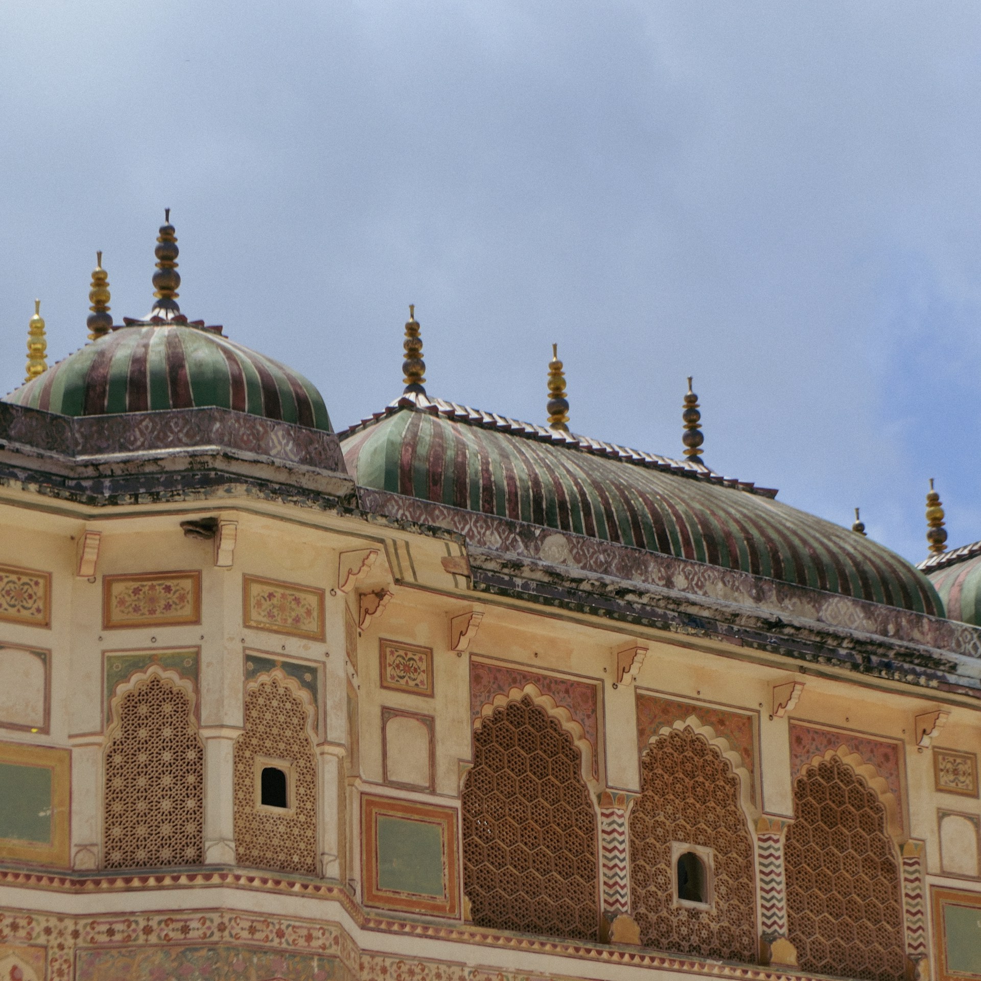 Close-up of detailed Mughal architecture showing ornate patterns and vibrant colors.