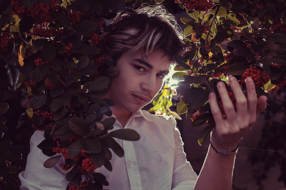 a man in a white shirt is holding berries