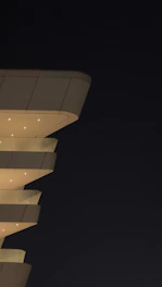 A modern tensile architecture structure illuminated at dusk, showcasing innovative design.