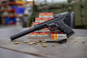 Close-up of a suppressor attached to a tactical handgun in an appointment-only showroom.