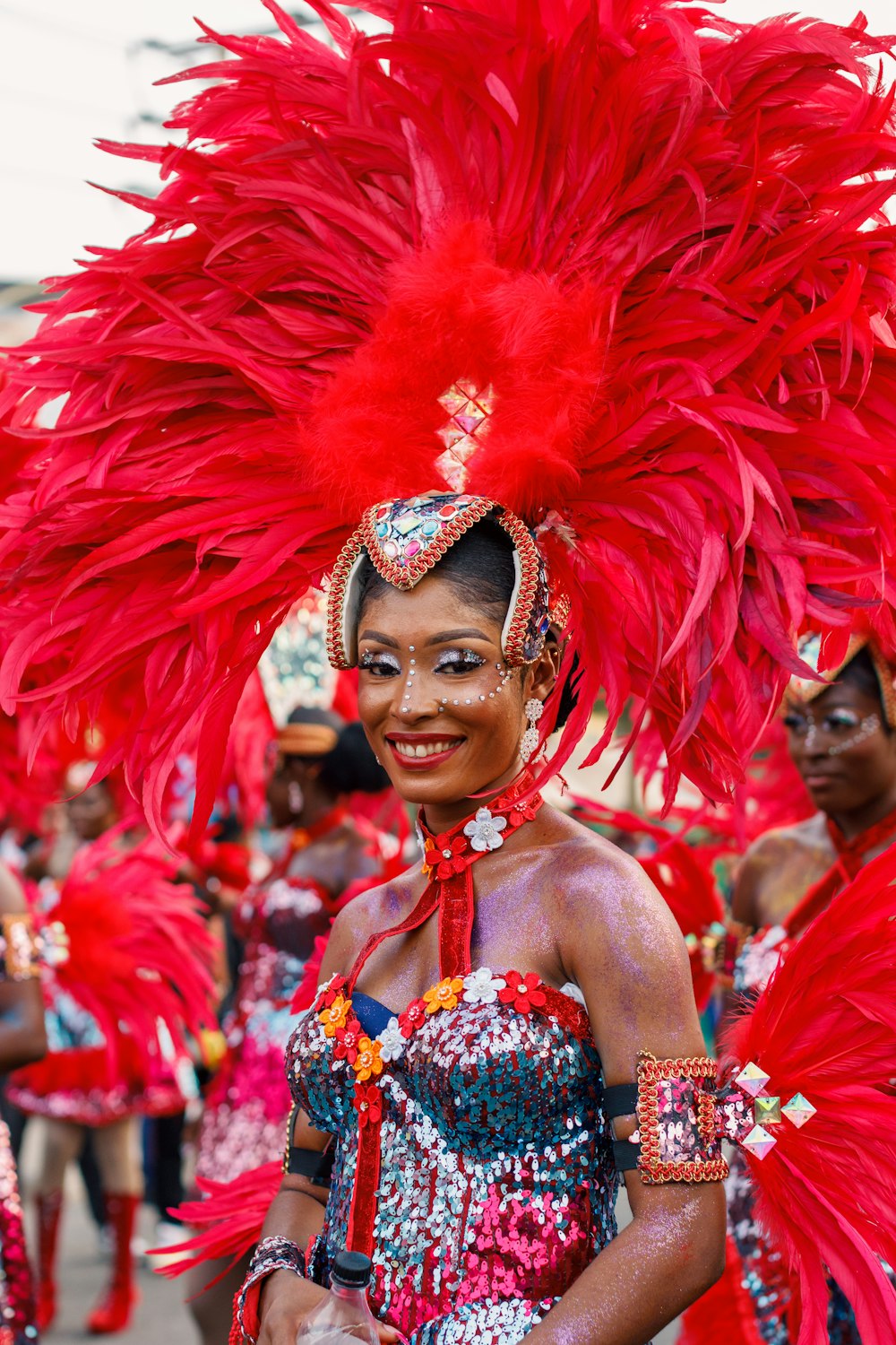 a woman in a red feathered dress and headdress