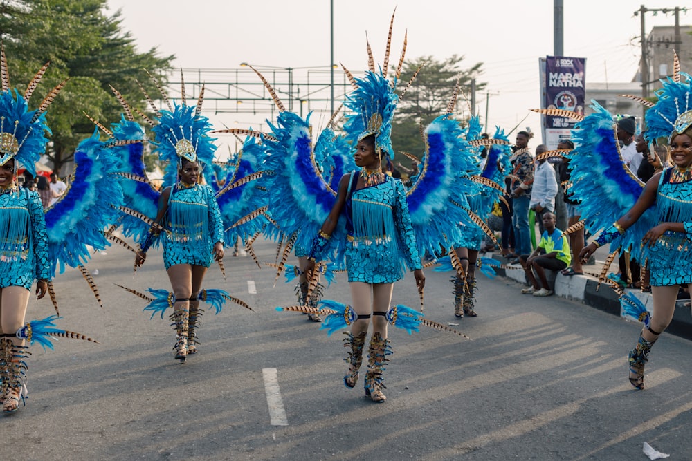 un grupo de mujeres con trajes azules caminando por una calle